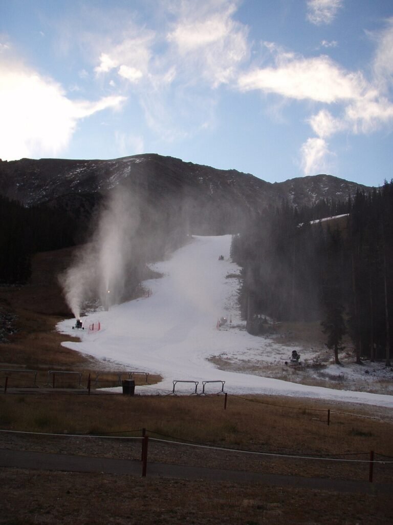 Arapahoe Basin'de kar topları ekim ayında pisti suni karla kaplıyor, arkada az karlı dağ sırtı