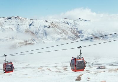Erciyes Kayak Merkezi'nde karlı dağların önünde kırmızı gondol kabinleri